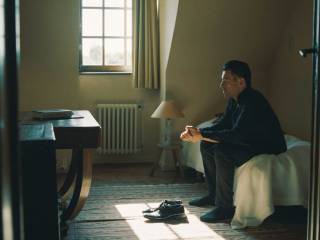 muž sedící na posteli