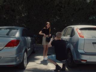 muž fotí ženu mezi dvěma auty